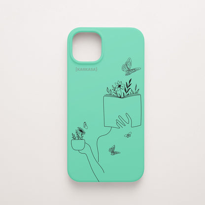 Funda de móvil KARKASA con ilustración lineal negra de una figura leyendo con flores y mariposas, en silicona mate Silk Touch verde menta.