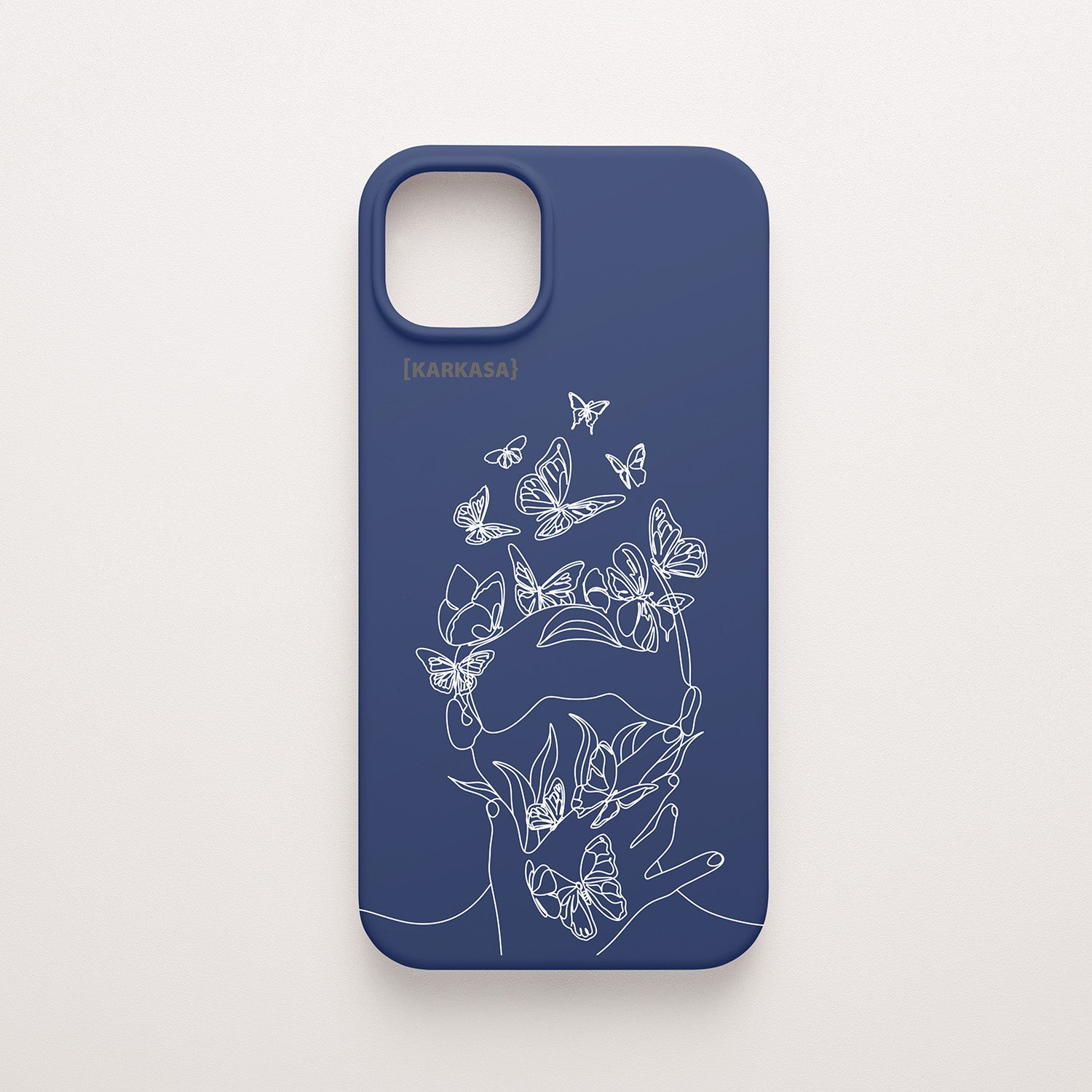 Funda de móvil KARKASA con diseño lineal blanco de silueta de mujer y mariposas, en silicona mate Silk Touch azul marino.