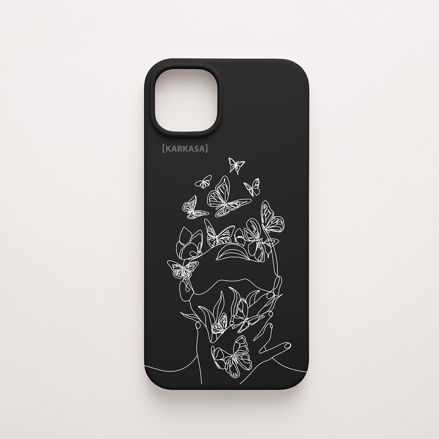 Funda de móvil KARKASA con diseño lineal blanco de silueta de mujer y mariposas, en silicona mate Silk Touch negra.