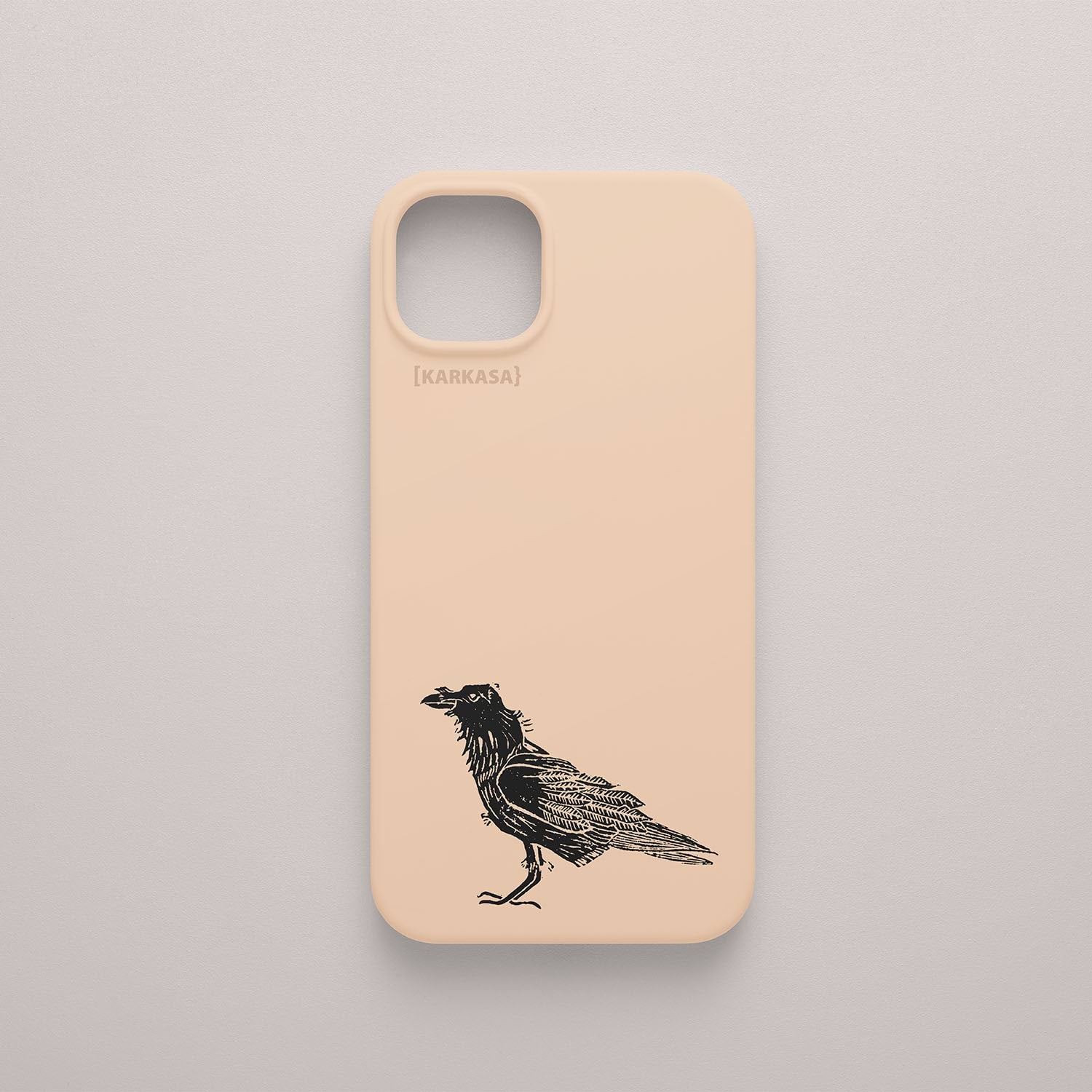 Funda KARKASA rosa nude con ilustración minimalista de un cuervo negro posado, dibujo en tinta del artista Daniel Buitrón.