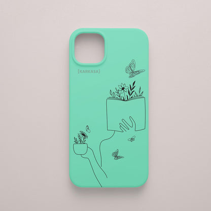 Funda de móvil KARKASA con ilustración lineal negra de una figura leyendo con flores y mariposas, en silicona mate Silk Touch verde menta.