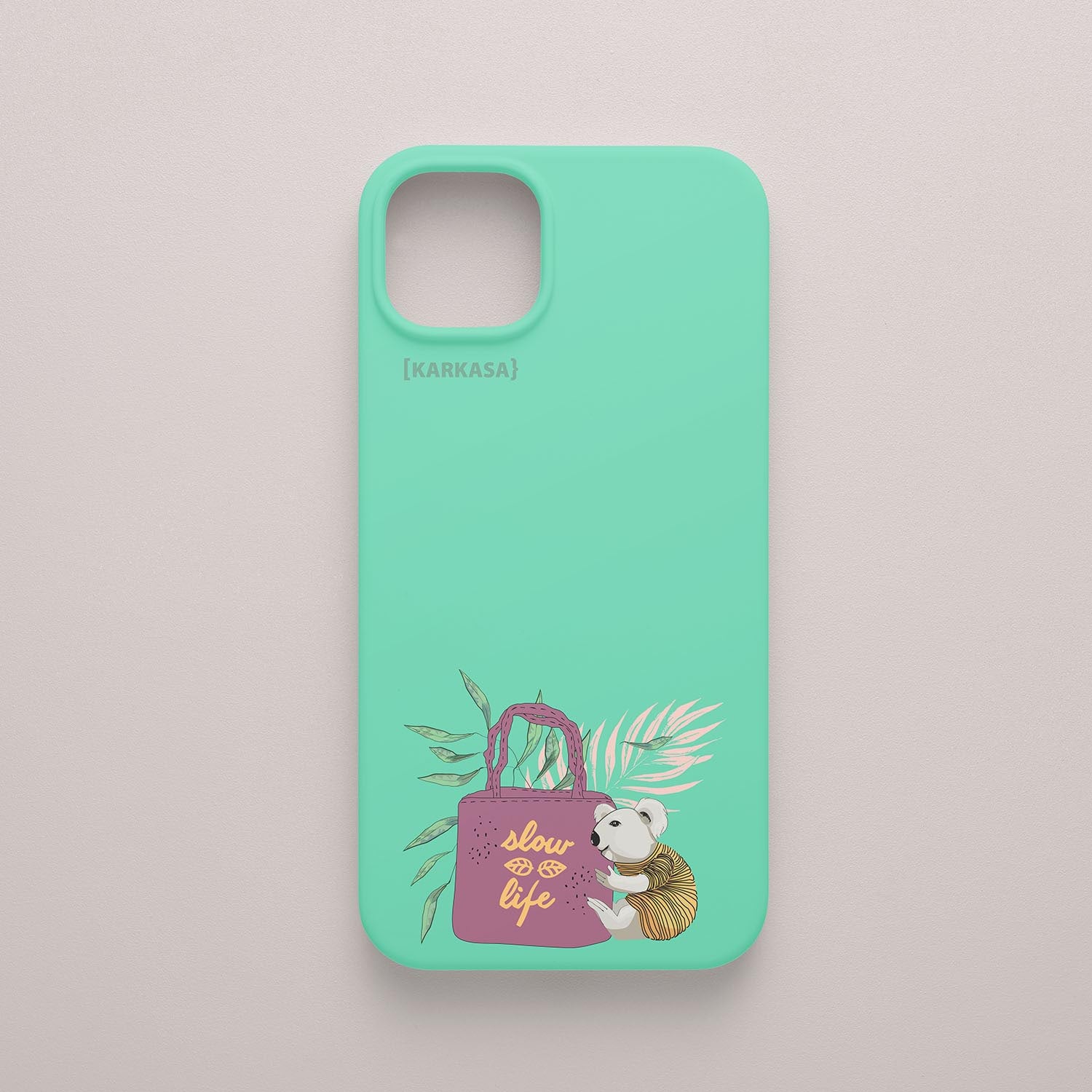 Funda KARKASA Silk Touch verde menta con ilustración de koala llevando un bolso rosa con la frase Slow Life y hojas tropicales. Carcasa estilo mindfulness.