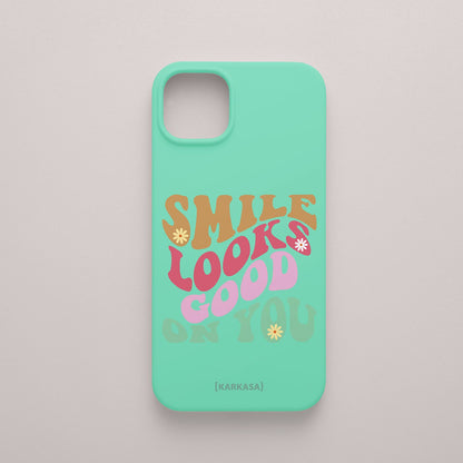 Funda KARKASA Silk Touch verde menta con frase Smile Looks Good On You en tipografía groovy psicodélica de colores. Carcasa mate de silicona para smartphone.